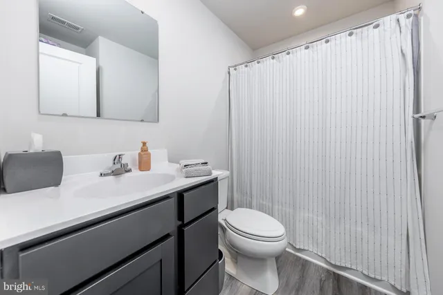 a bathroom with a toilet a sink and mirror