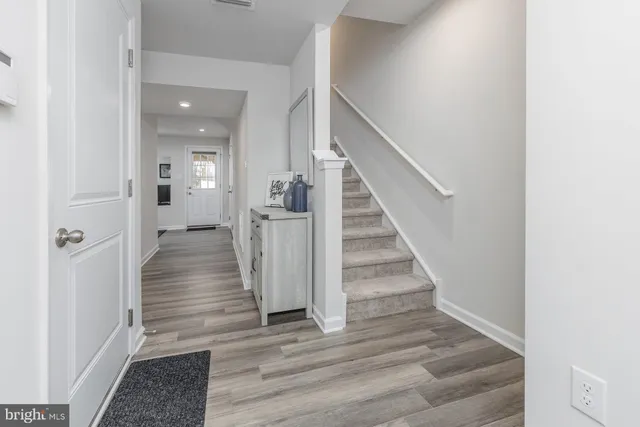 a view of a hallway with wooden floor and entryway