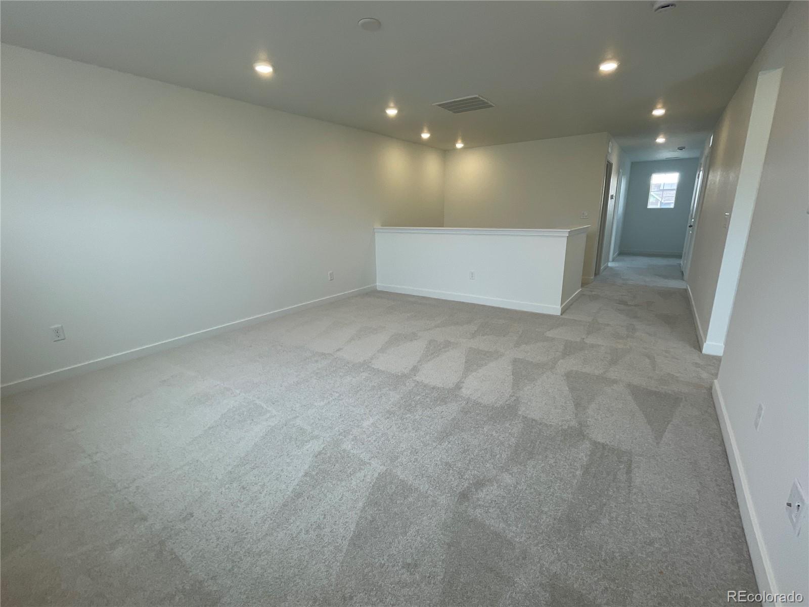 12883 Range Street Firestone, CO 80504 - Photo 13 of 39 an empty room with wooden floor and windows