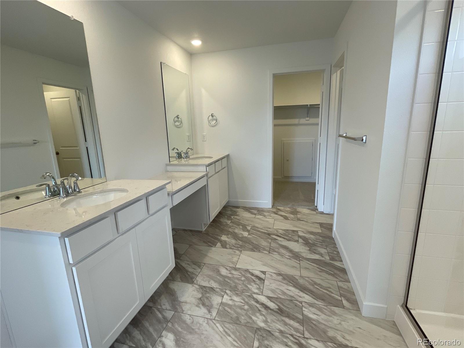 12883 Range Street Firestone, CO 80504 - Photo 15 of 39 a spacious bathroom with a double vanity sink a mirror and a shower
