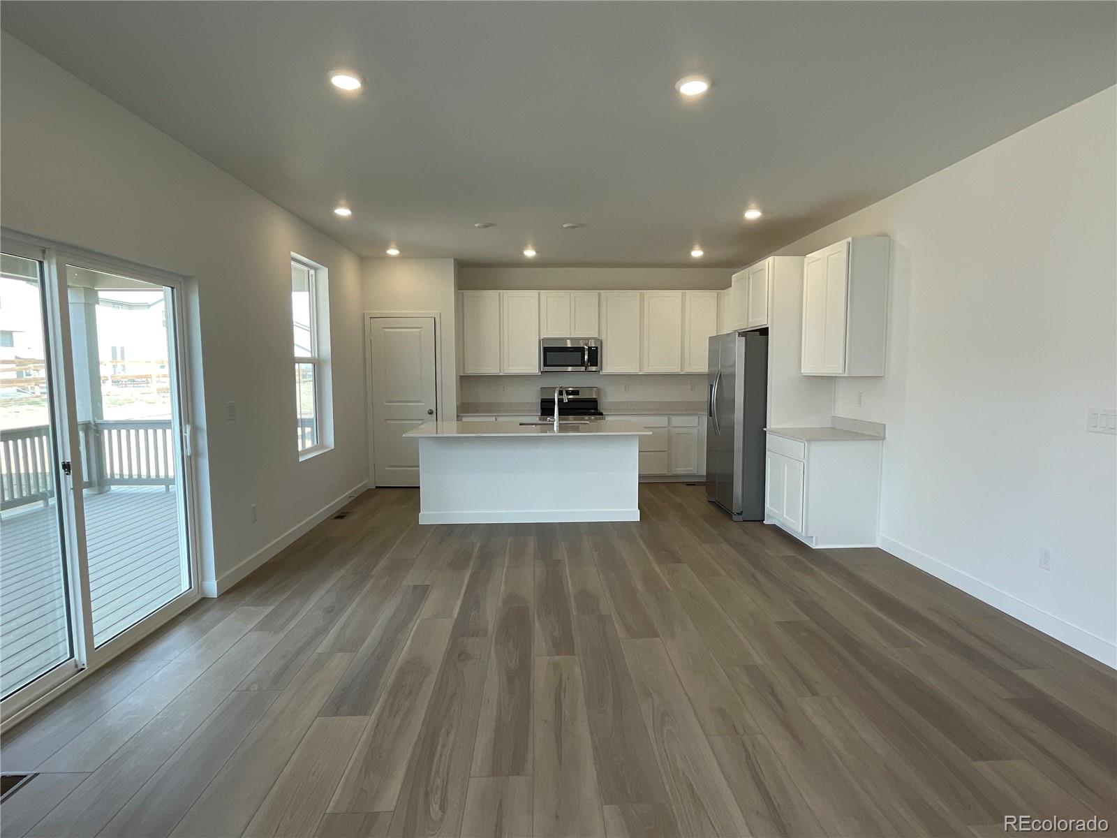 12883 Range Street Firestone, CO 80504 - Photo 2 of 39 a view of kitchen with refrigerator stove and wooden floor