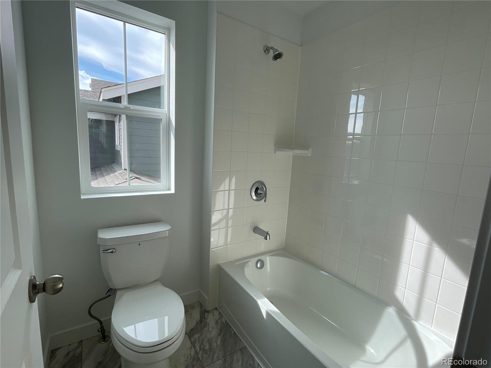 12883 Range Street Firestone, CO 80504 - Photo 21 of 39 a white toilet sitting next to a bathtub