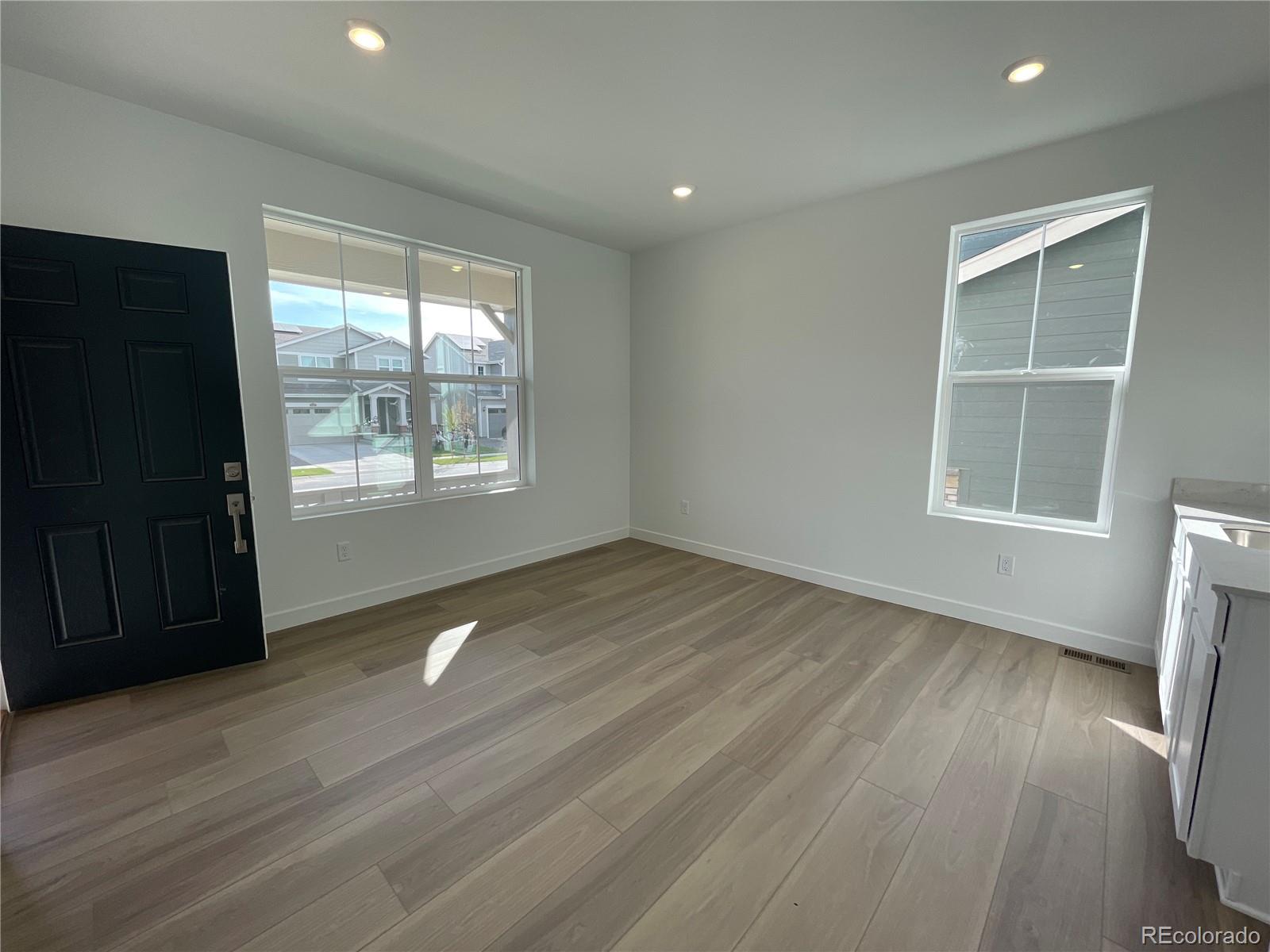 12883 Range Street Firestone, CO 80504 - Photo 6 of 39 an empty room with wooden floor and windows
