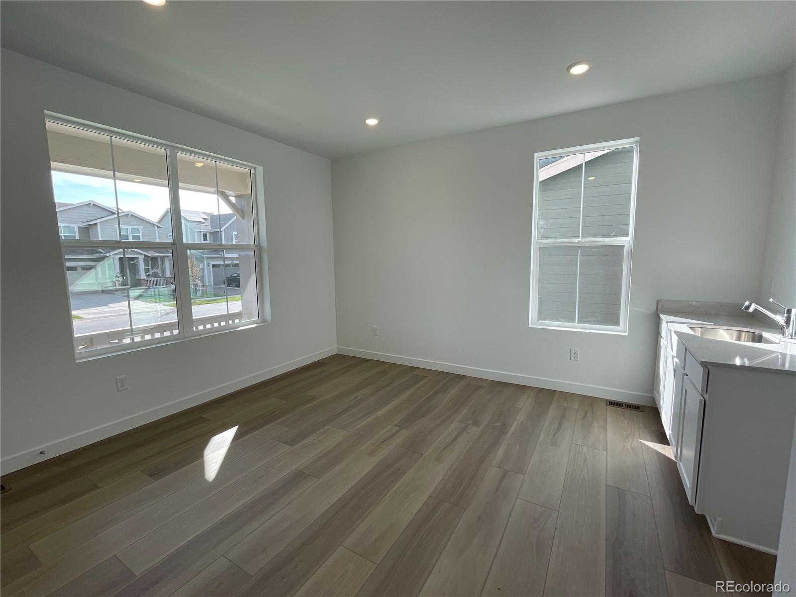 12883 Range Street Firestone, CO 80504 - Photo 7 of 39 a view of an empty room with wooden floor and a window