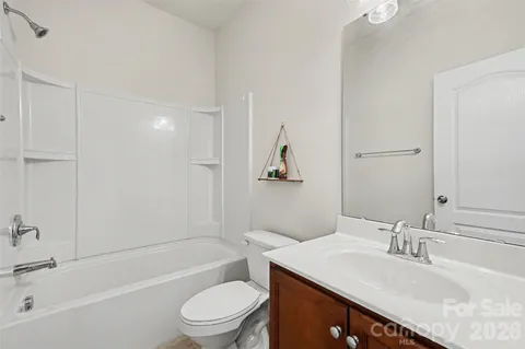 a bathroom with a granite countertop sink a toilet and shower