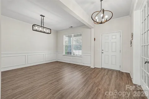 a view of empty room with wooden floor and window