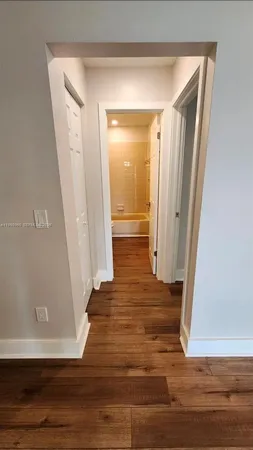 a view of a hallway with wooden floor and staircase