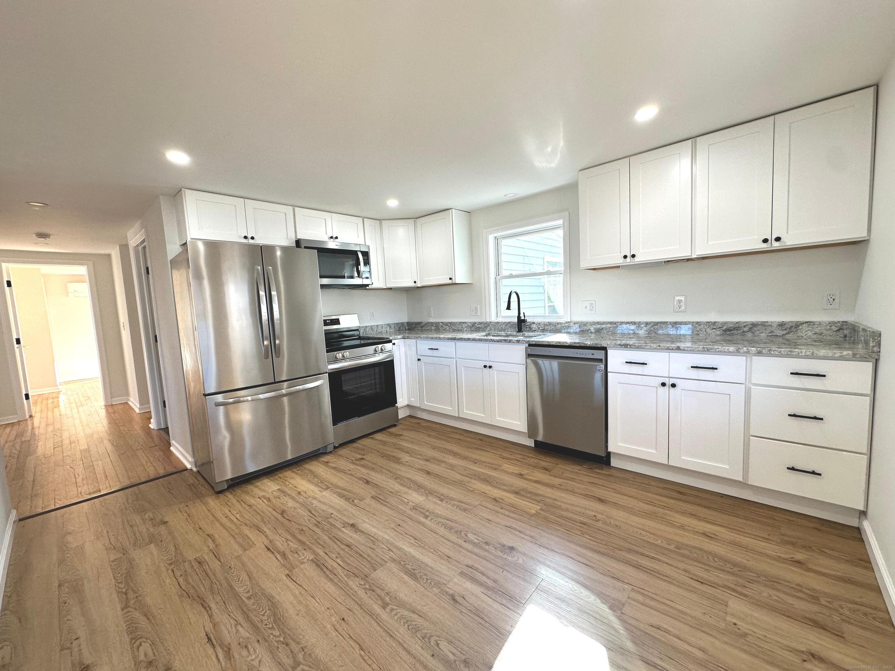 a kitchen with stainless steel appliances a refrigerator sink and cabinets