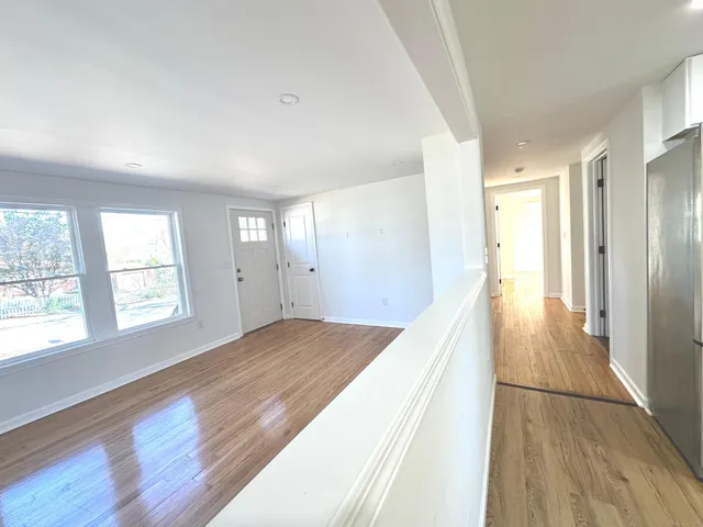 a view of hallway with wooden floor and window