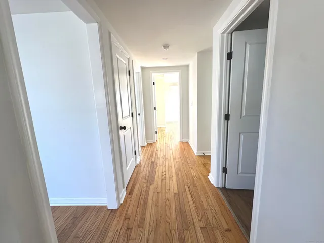 a view of a room with wooden floor and a bathroom