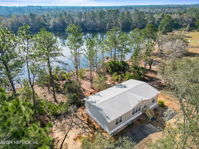 a view of a house with a yard and large tree