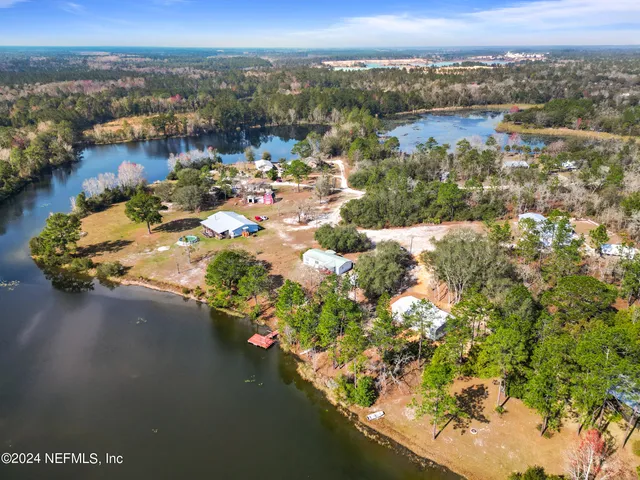 an aerial view of residential houses with outdoor space and trees