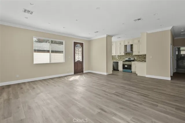 a view of a livingroom with a kitchen counter top space and stainless steel appliances