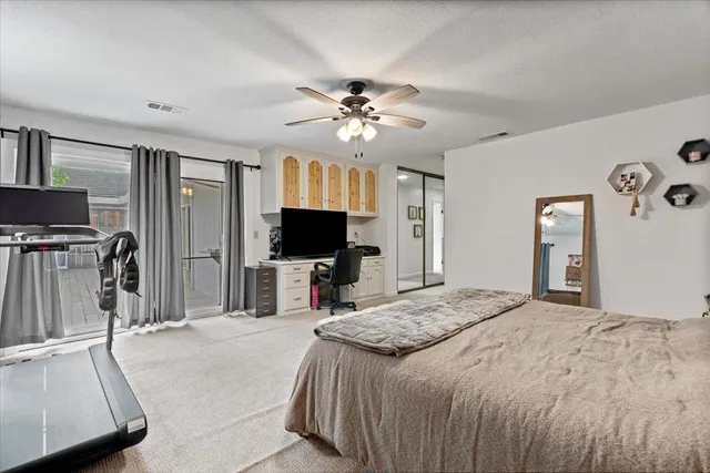 a large kitchen with granite countertop a sink and white cabinets