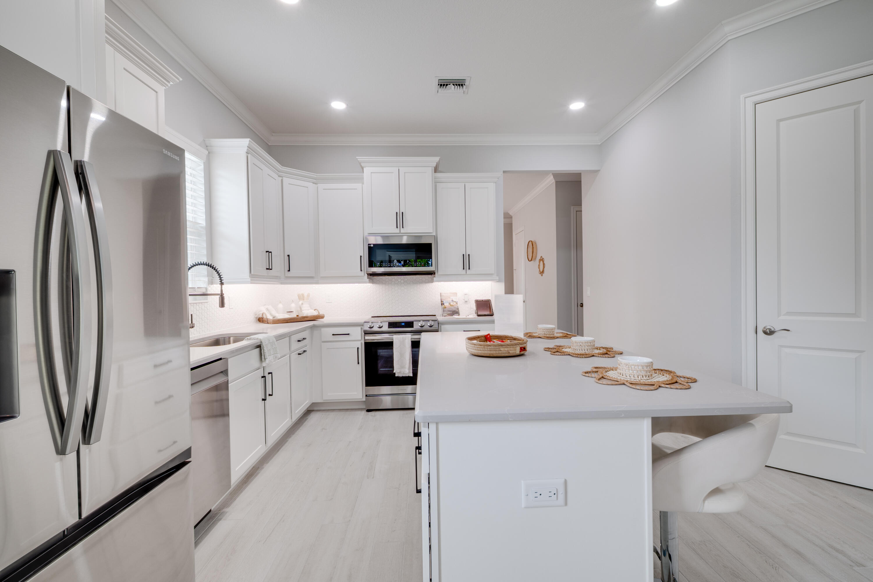 2005 Bridgepointe Circle, Unit 99 Vero Beach, FL 32967 - Photo 7 of 37 a kitchen with a sink a stove a refrigerator and white cabinets