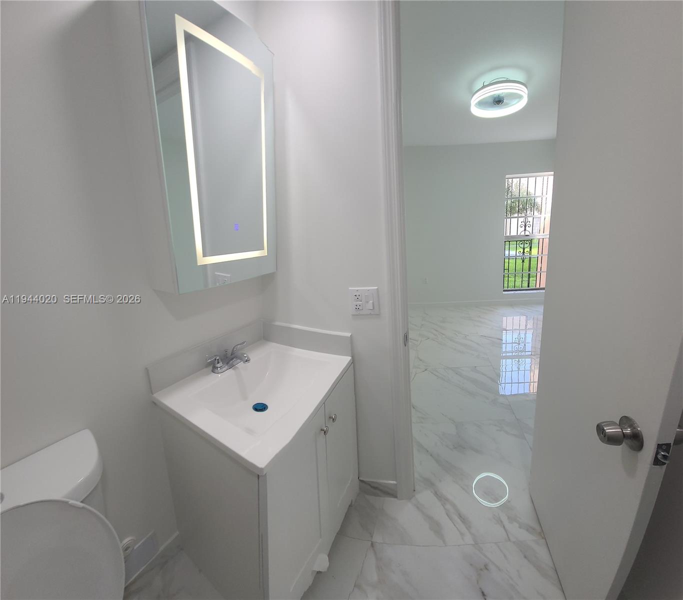 4713 Northwest 7th Street, Unit 1041 Miami, FL 33126 - Photo 14 of 19 a bathroom with a toilet sink and mirror