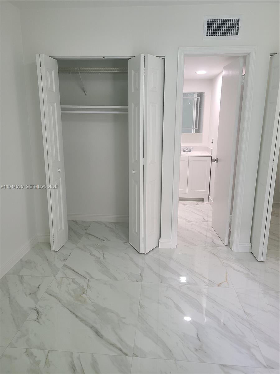 4713 Northwest 7th Street, Unit 1041 Miami, FL 33126 - Photo 6 of 19 a view of a hallway with closet and a bathroom