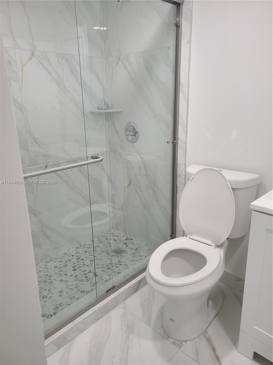 4713 Northwest 7th Street, Unit 1041 Miami, FL 33126 - Photo 9 of 19 a white toilet sitting next to a shower