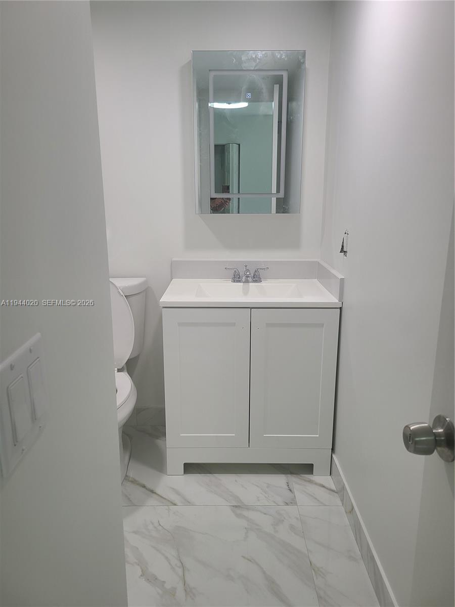 4713 Northwest 7th Street, Unit 1041 Miami, FL 33126 - Photo 10 of 19 a bathroom with a sink toilet and mirror