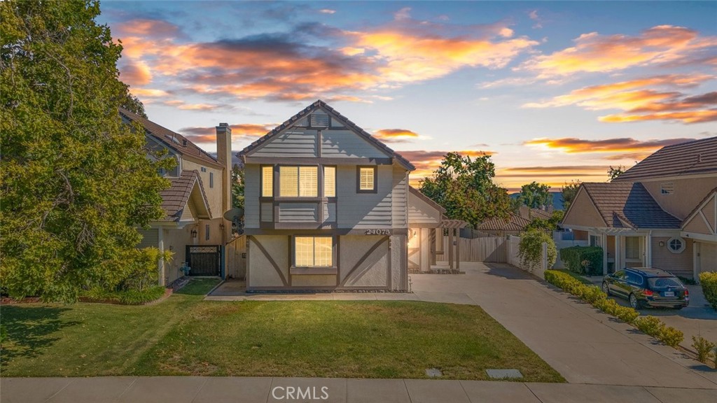 a view of a brick house next to a yard with big trees