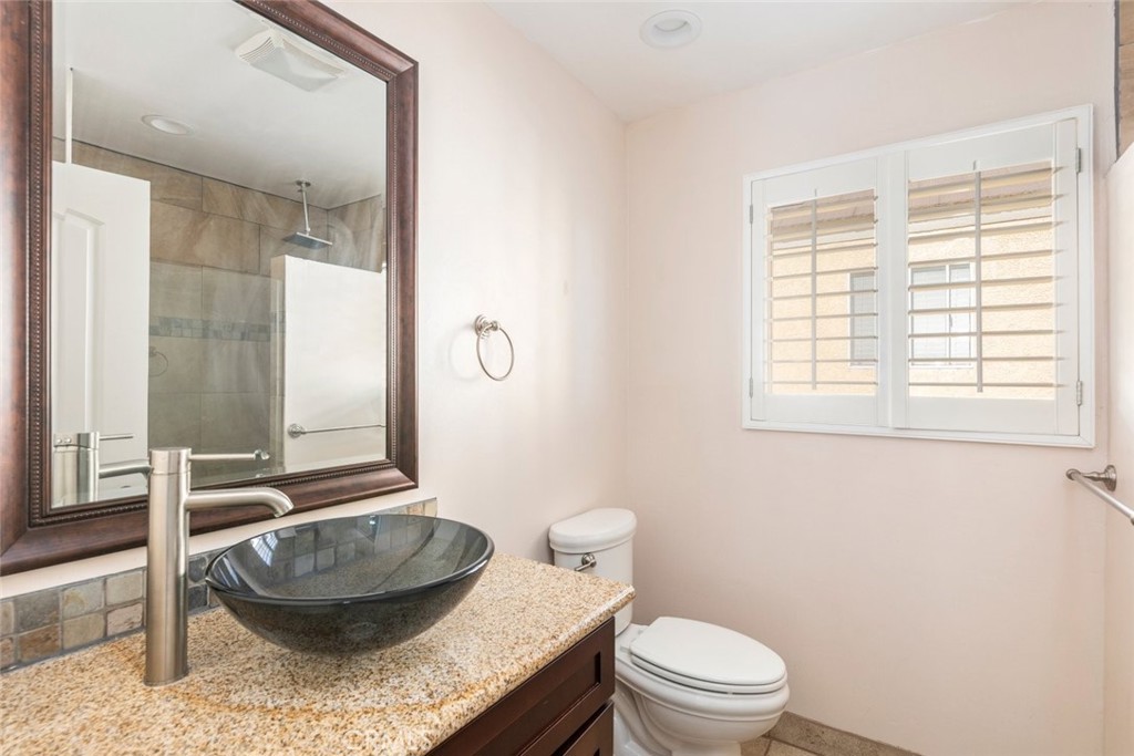 24075 Falconer Drive Murrieta, CA 92562 - Photo 14 of 25 a bathroom with a granite countertop toilet and a sink