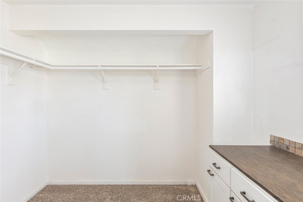 24075 Falconer Drive Murrieta, CA 92562 - Photo 18 of 25 a view of a kitchen with white cabinets and a wooden floor