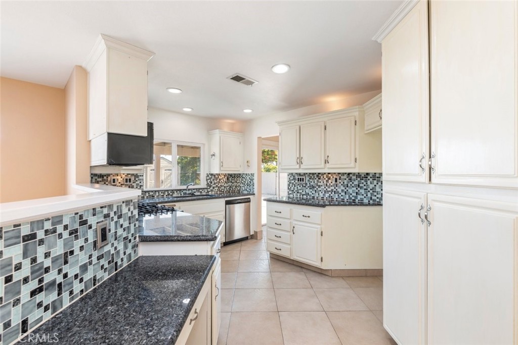 24075 Falconer Drive Murrieta, CA 92562 - Photo 8 of 25 a kitchen with stainless steel appliances kitchen island granite countertop a refrigerator and a stove top oven