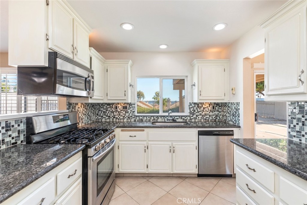 24075 Falconer Drive Murrieta, CA 92562 - Photo 9 of 25 a kitchen with stainless steel appliances granite countertop a sink stove and cabinets