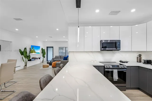 a kitchen with a sink stainless steel appliances and white cabinets