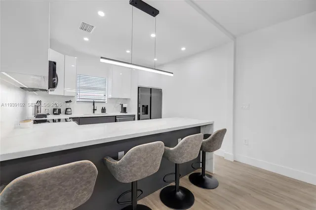 a kitchen with stainless steel appliances granite countertop a sink a window and cabinets