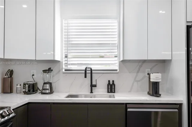 a kitchen with stainless steel appliances granite countertop a sink a stove and a microwave