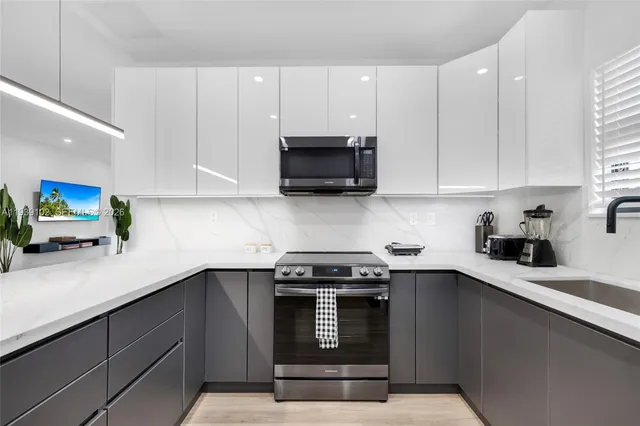 a room with a potted plant on the counter and cabinets