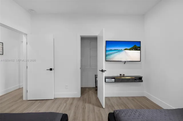a bedroom with two beds and a flat screen tv