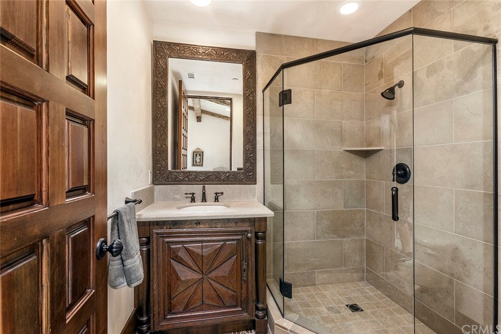 82 Golden Eagle Irvine, CA 92603 - Photo 19 of 40 a bathroom with a shower sink vanity and mirror