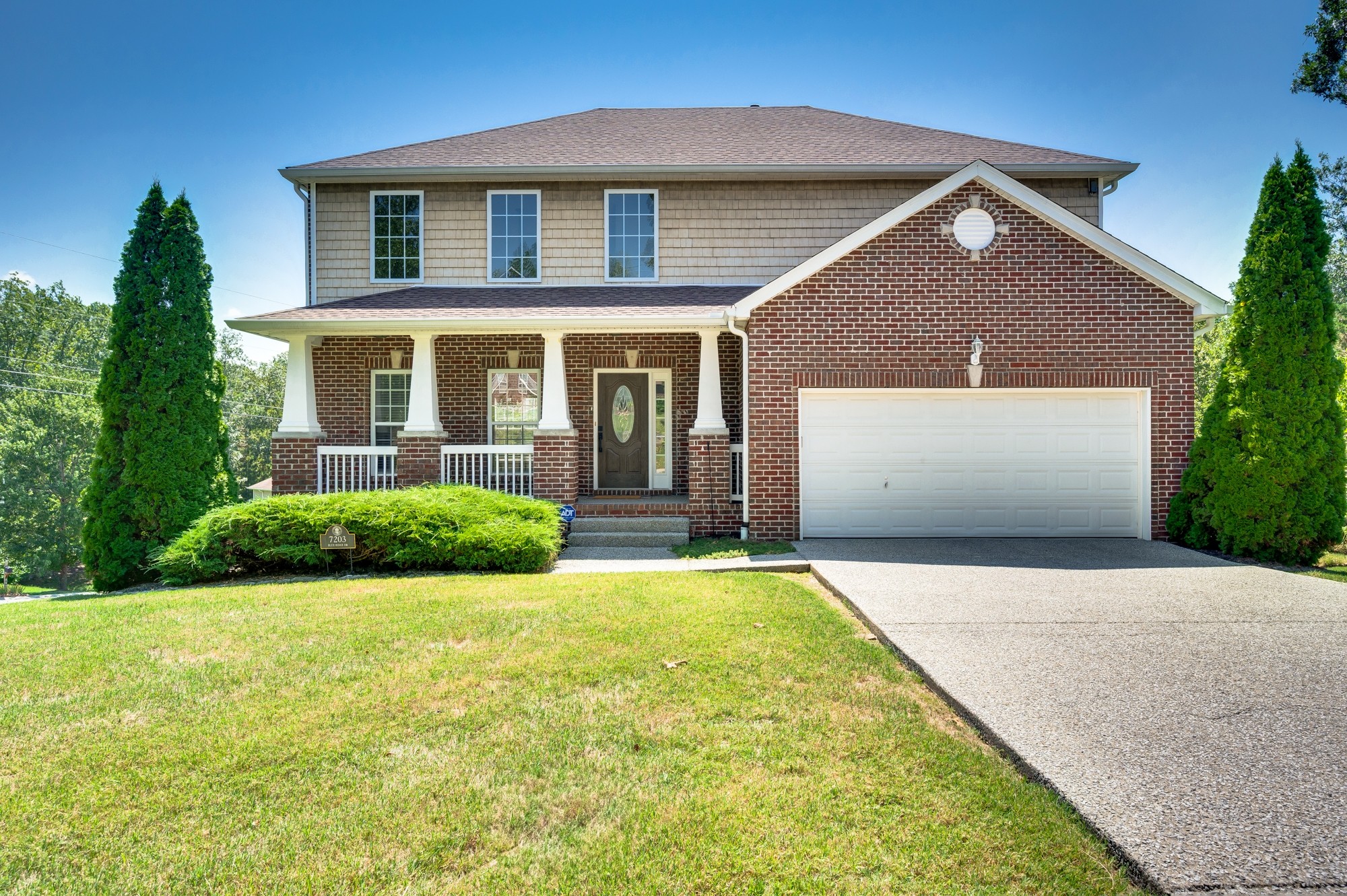 a front view of a house with yard and green space