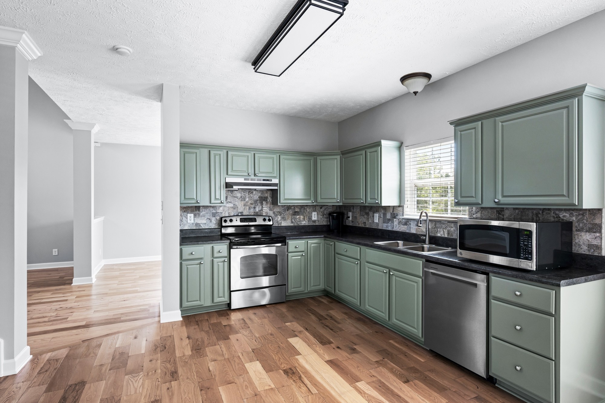 7203 Blue Ridge Drive Fairview, TN 37062 - Photo 19 of 65 a kitchen with stainless steel appliances granite countertop a stove top oven a sink dishwasher a refrigerator and cabinets with wooden floor