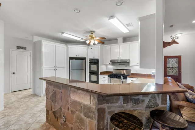 a kitchen with granite countertop a sink and a refrigerator