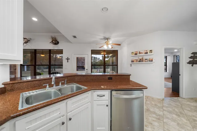 a kitchen with granite countertop a sink stove and cabinets