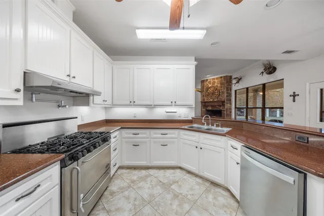 a kitchen with granite countertop a stove and a white cabinets