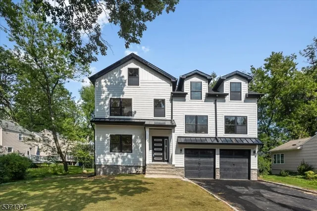 a front view of a house with a yard garage and outdoor seating