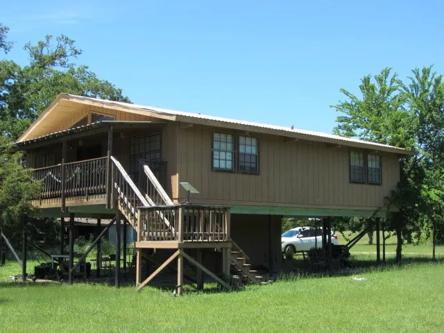 a view of house with yard and outdoor seating