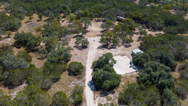 an aerial view of residential houses with outdoor space and trees