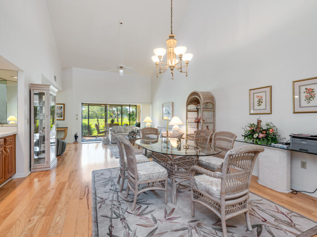602 Augusta Boulevard, Unit 3 Naples, FL 34113 - Photo 4 of 8 a view of a dining room with furniture wooden floor and chandelier