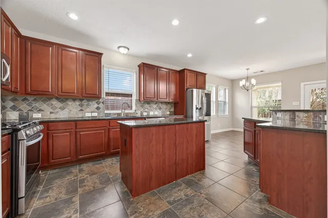 a kitchen with stainless steel appliances granite countertop wooden cabinets a sink and dishwasher
