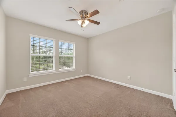 an empty room with a window and a ceiling fan