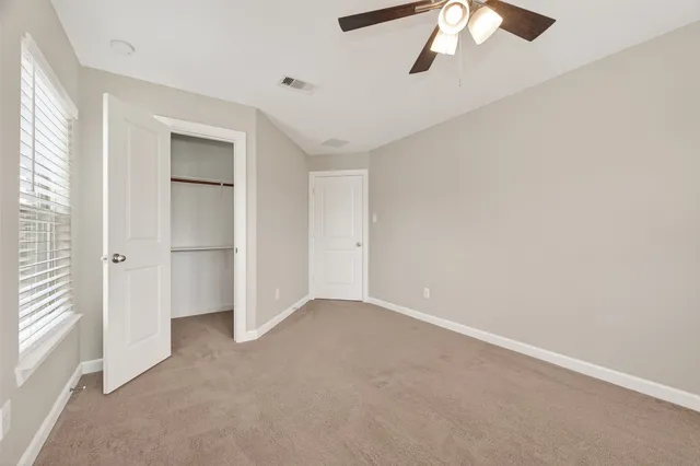 an empty room with chandelier fan