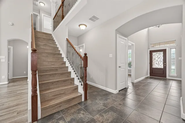 a view of a hallway with entryway and stairs