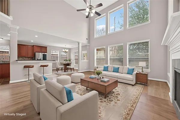 a living room with furniture wooden floor and a large window