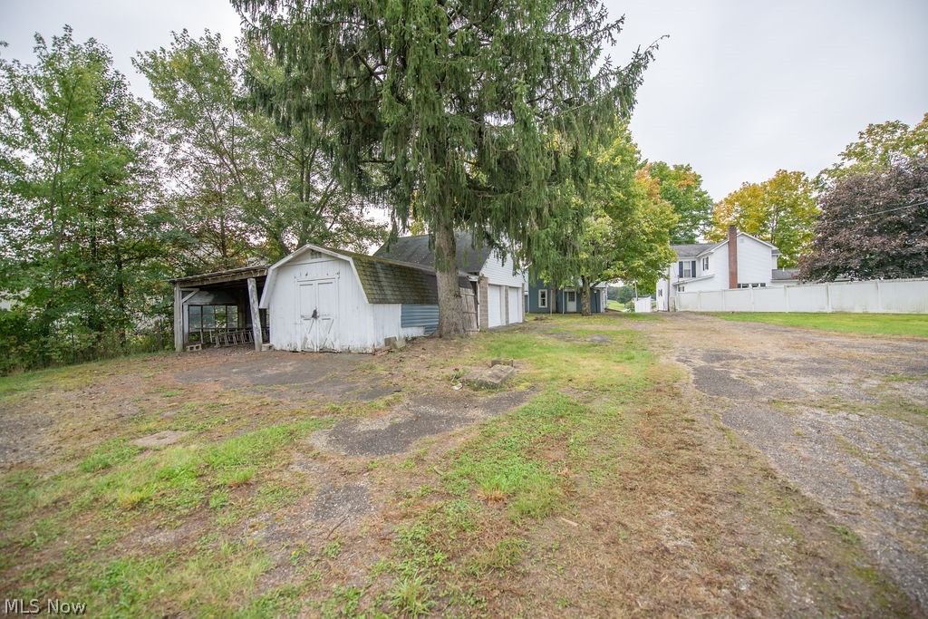 2468 Tabor Ridge Road Northeast New Philadelphia, OH 44663 - Photo 6 of 33 Yard area featuring 2 car garage and shed