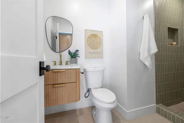 a bathroom with a toilet sink vanity tub and mirror